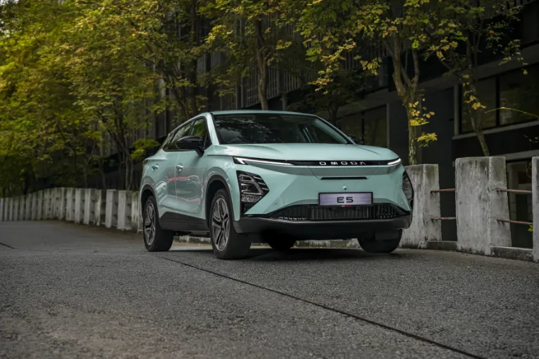 Omoda E5 — front three-quarter exterior view among trees