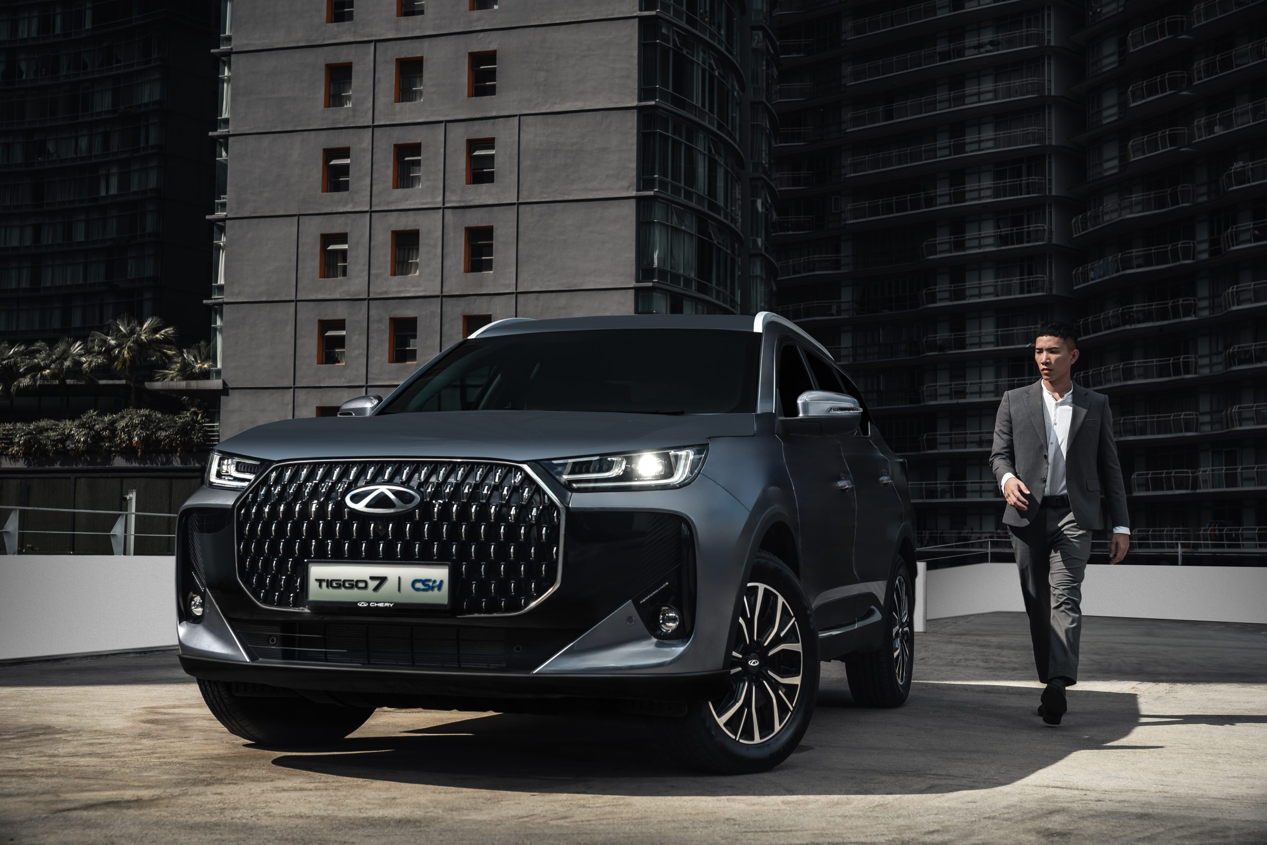 Chery Tiggo 7 PHEV — rear three-quarter view against a city skyline
