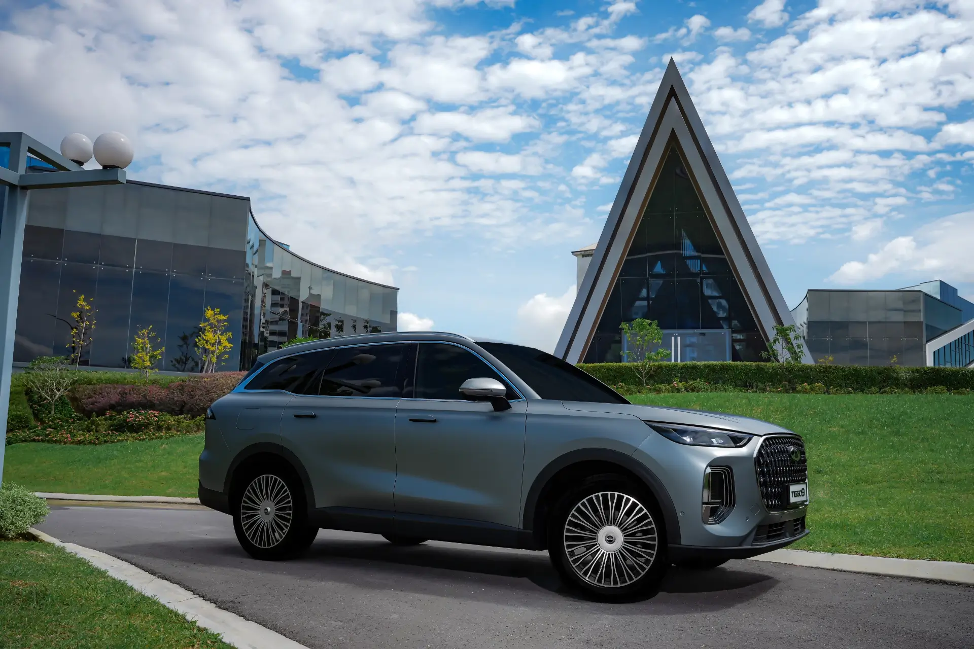 Chery Tiggo 9 — side profile exterior view outside a modern building