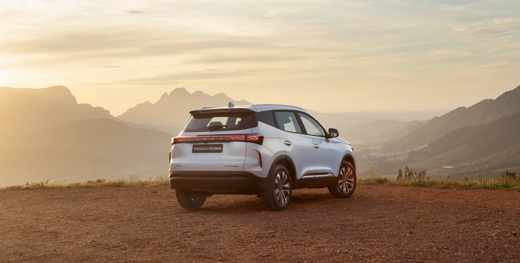 Tiggo Cross Turbo — rear three-quarter view at sunset in the mountains